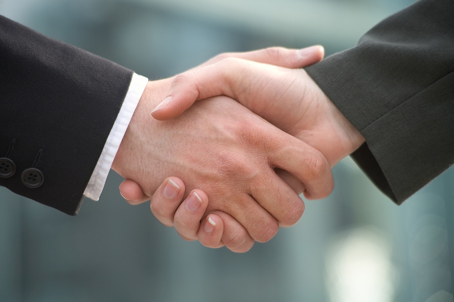 two businessman shake hands- jackimwoods